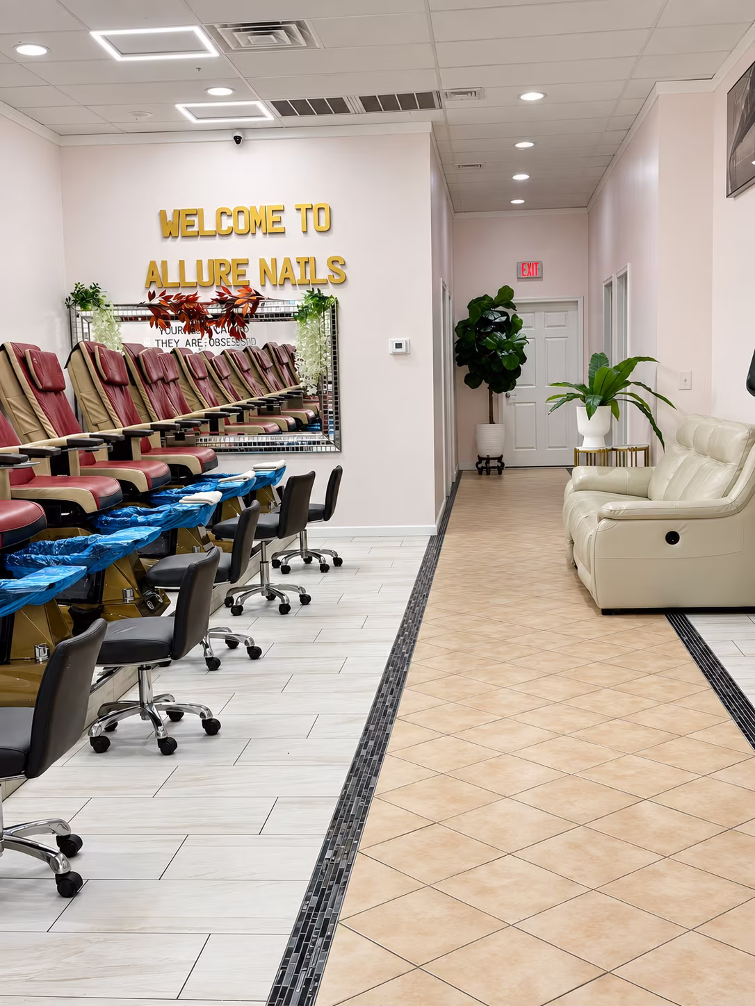 Welcome to Allure Nails sign above the row of pedicure chairs and the lounge seating